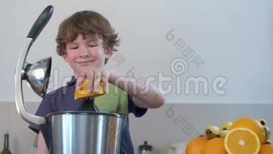 年轻有趣的白种人男孩在厨房用电<strong>榨</strong>汁机和微笑制作鲜橙<strong>果汁</strong>
